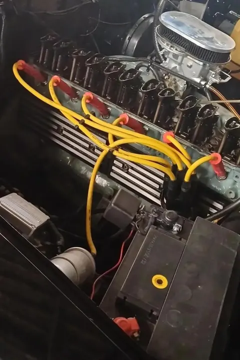Motor seis cilindros em linha visto de cima, com seis cabos de vela amarelos